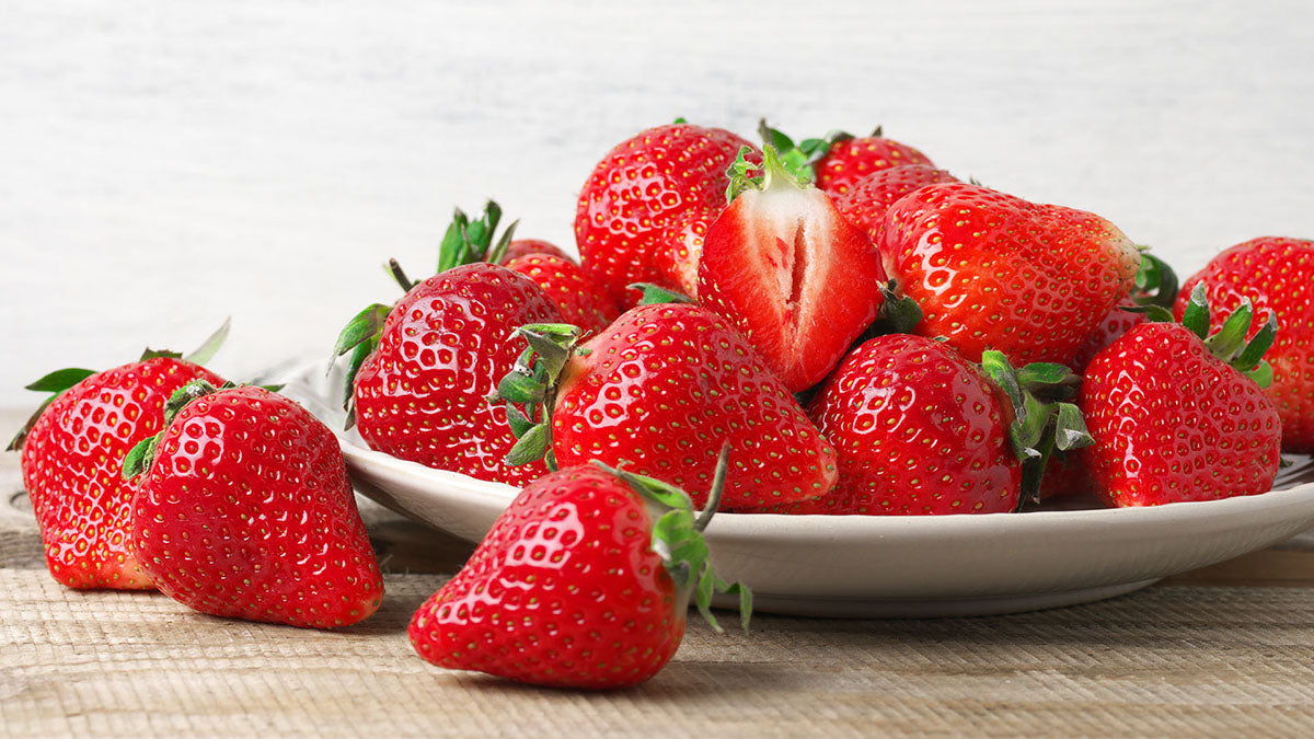 Fresh strawberries on a white plate. Strawberries are a nutritious and healthy treat for dogs.