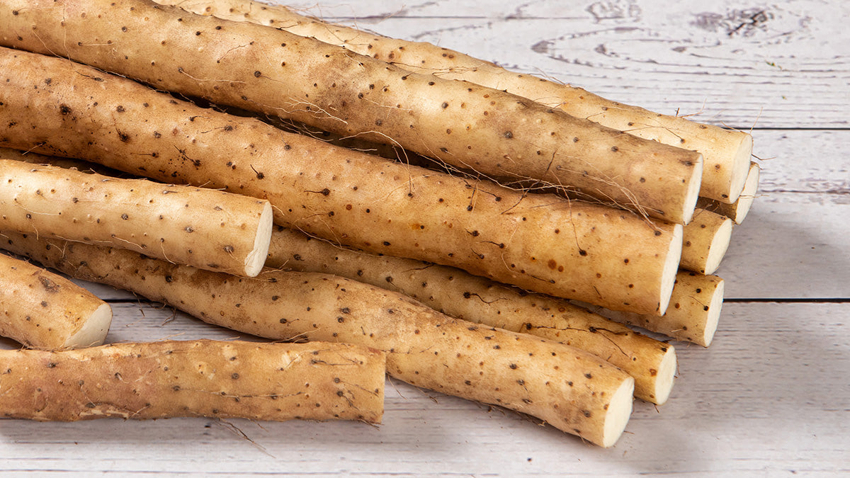 Stack of raw yams on a wooden surface