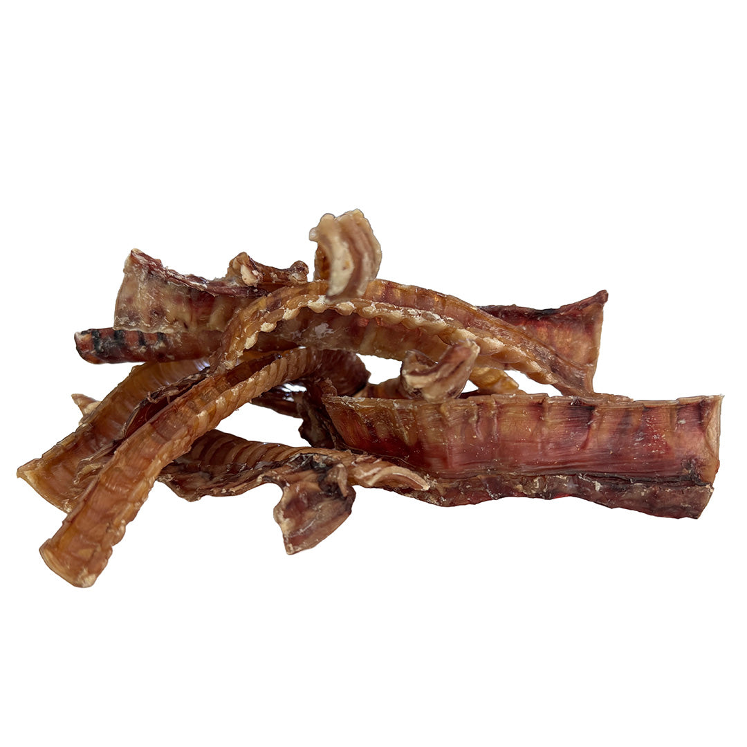 A pile of dehydrated beef trachea strips for dogs on a solid white background.